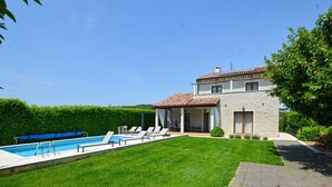 A two-story house with a stone facade, a swimming pool, and a well-maintained lawn. - Sophisticated and Chic Villa with Pool - Four Bedroom Villa with Pool (Kanfanar)