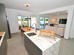 Enjoy a spacious kitchen with a dining area, comfortable living space, and a balcony with outdoor views.