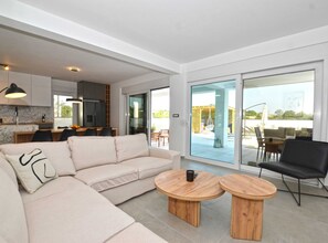 Relax in a spacious living area with a sofa, coffee tables, and a leather armchair.