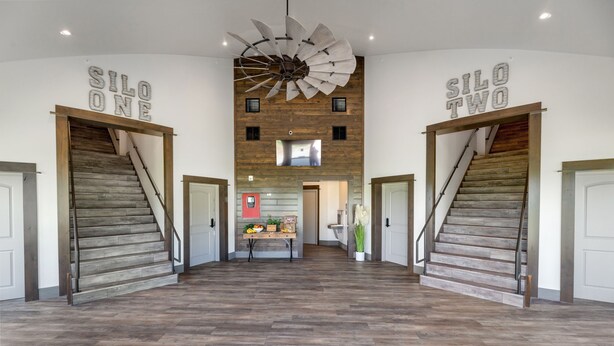 Ruime interieur met een centrale trap, aan weerszijden geflankeerd door twee deuren met de aanduiding 'SILO ONE' en 'SILO TWO'.