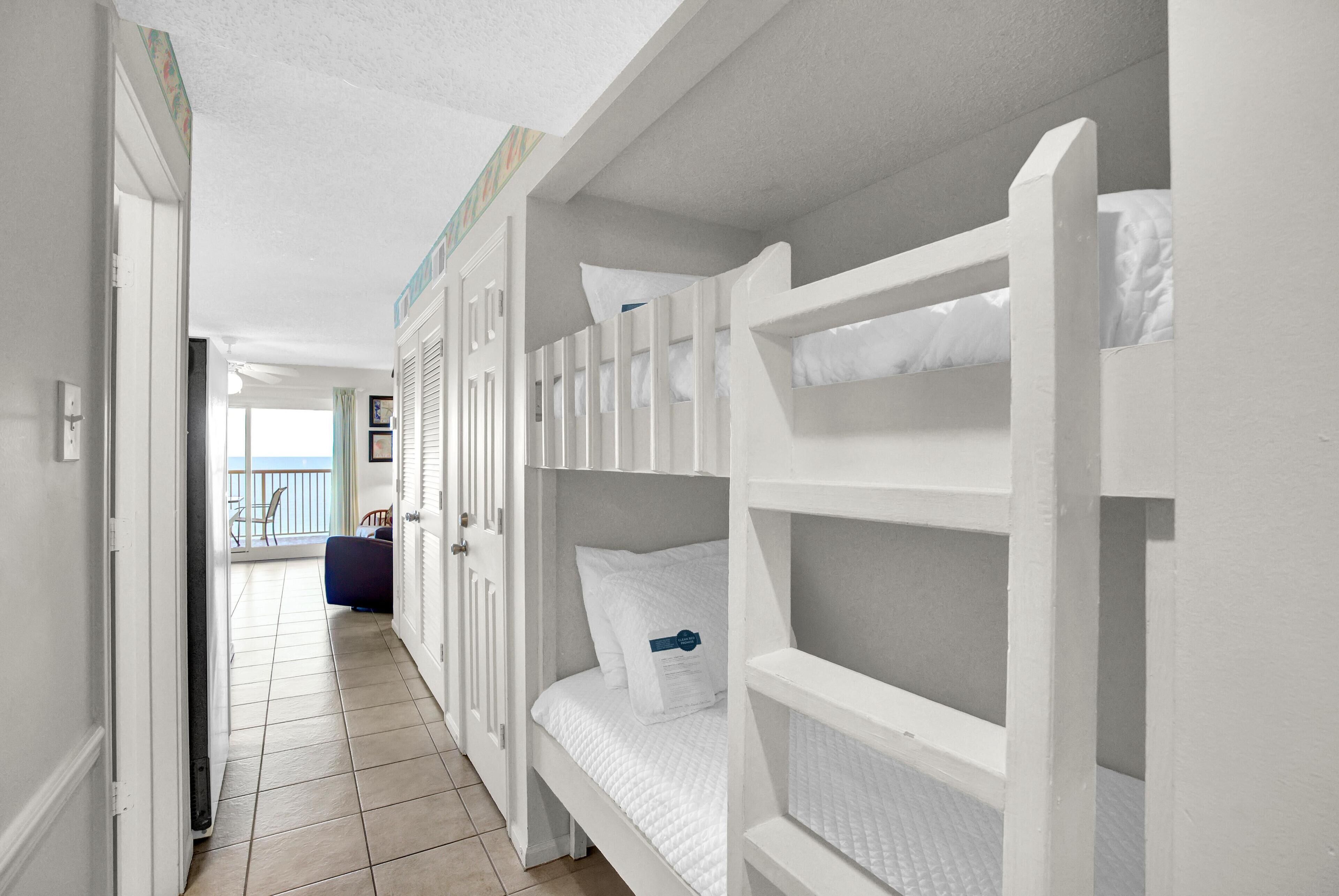 Habitación de hotel con literas, balcón y vista al mar.