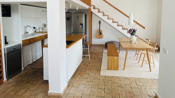 Eine moderne Küche mit weißen Schränken, einer Holz Arbeitsplatte und einem eingebauten Geschirrspüler.