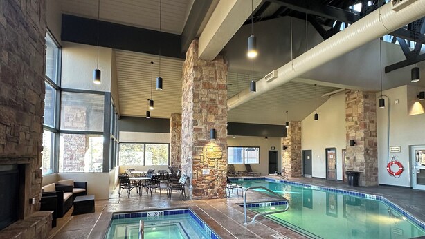 Un área de piscina interior con paredes de piedra, varias piscinas y zonas de estar.