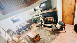 A spacious living area with a brown leather sofa, a wooden coffee table, and a fireplace. - Cozy 3-bedroom cottage with AC and WiFi in lovely Albrightsville (Albrightsville)