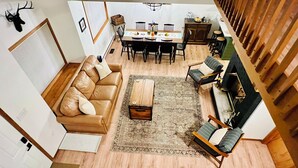 A spacious living room with a brown leather sofa, a wooden coffee table, and a dining area with a wooden table and chairs. - Cozy 3-bedroom cottage with AC and WiFi in lovely Albrightsville (Albrightsville)