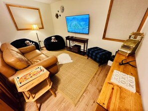 TV connectée, cheminée, livres, chaîne hi-fi