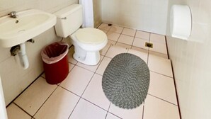 Un baño pequeño con lavamanos, inodoro y ducha.