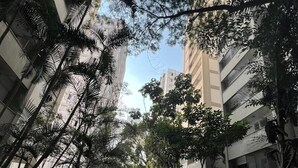 A pathway lined with trees and buildings, leading towards a distant structure. - Solimoes/IBC/Interlagos Automobile/Monica's PQ/Congonhas Airport/Expo Transameri (Campo Grande)