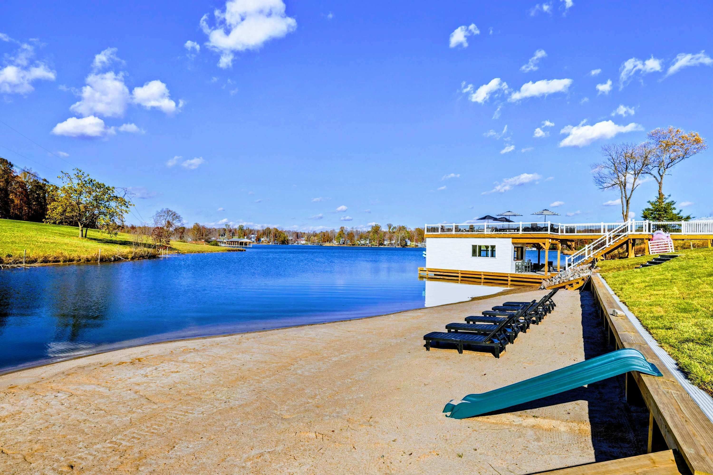 Un hôtel situé au bord d’un lac, doté d’un quai, de chaises longues et d’un petit bâtiment.