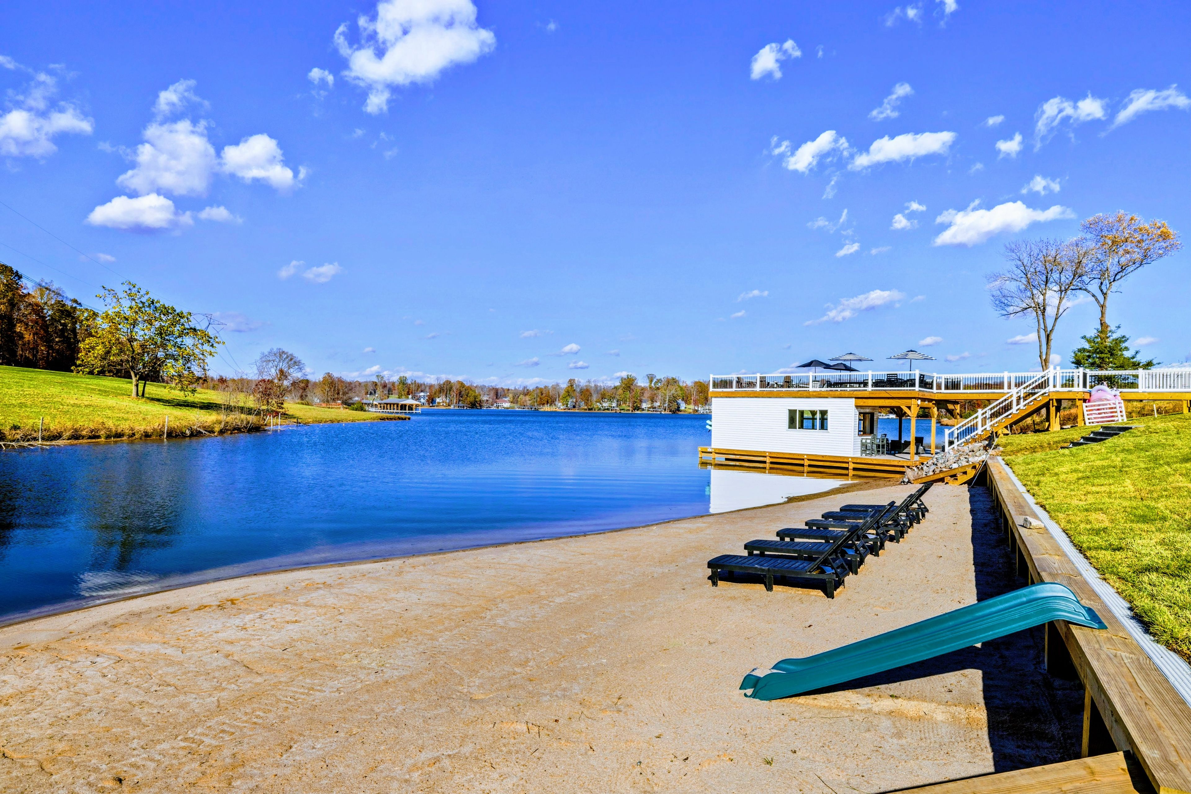 Une terrasse au bord du lac, dotée de chaises longues et d’un espace aménagé près de la piscine.