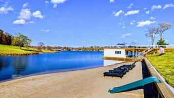 Une terrasse au bord du lac, dotée de chaises longues et d’un espace aménagé près de la piscine.