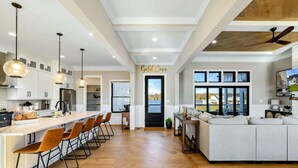 A modern kitchen with a bar area, a large window, and a ceiling fan. - Lakefront Lake Anna, Pool, Beach, Dock (Mineral)