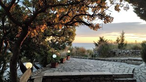 A stone patio with potted plants and a wooden bench. - Cliff House with beautiful sea view. Panoramic views just infront of our terrace (Krstac)