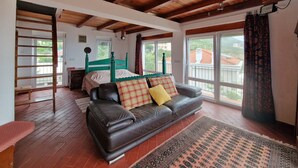 A bedroom with a wooden ceiling, a green bed, a brown leather sofa, and a patterned rug. - Cliff House with beautiful sea view. Panoramic views just infront of our terrace (Krstac)