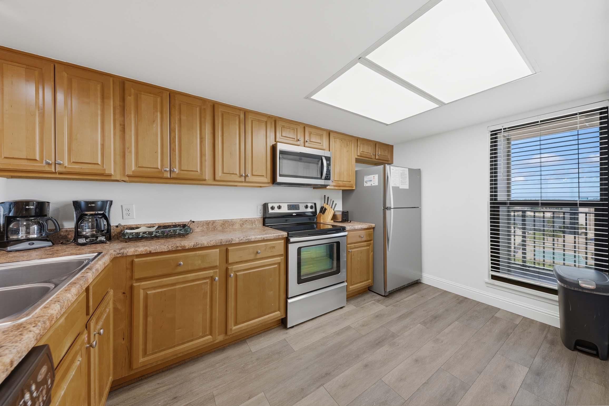A modern kitchen with wooden cabinets, a microwave, a stove, and a refrigerator.