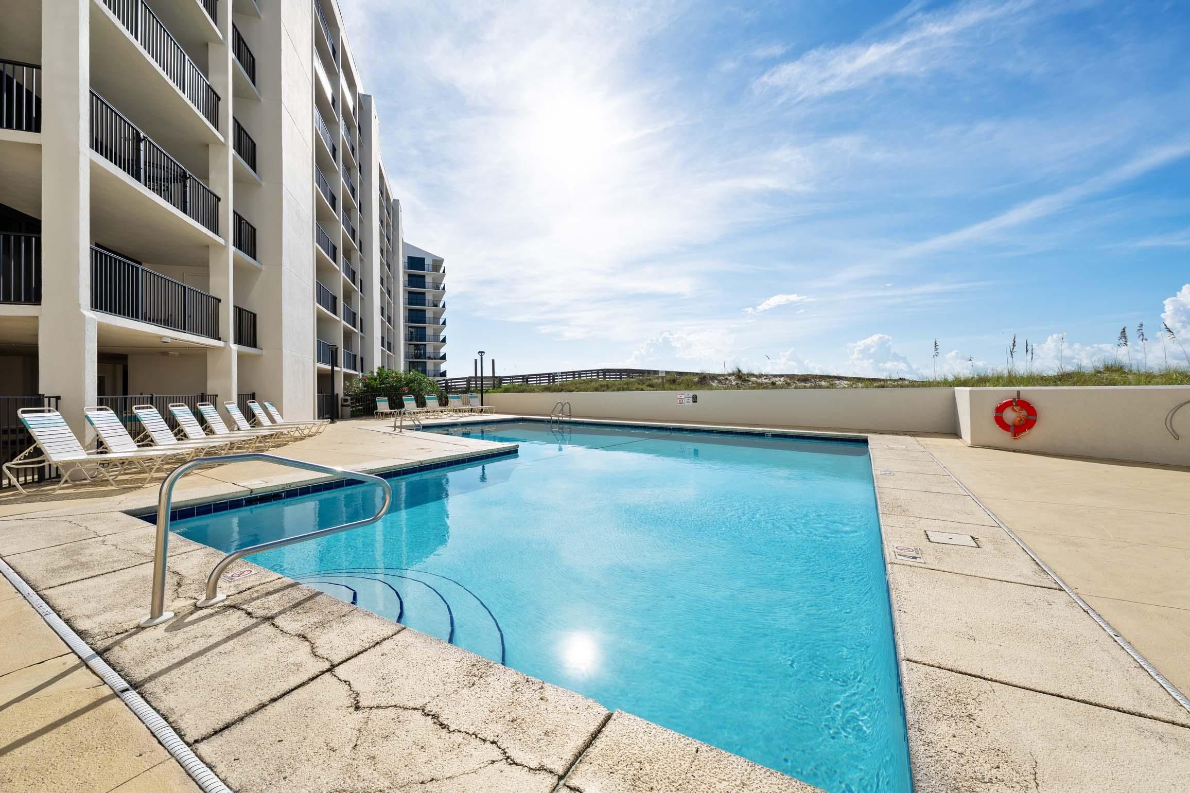 A swimming pool with a view of a high-rise building and a clear sky.