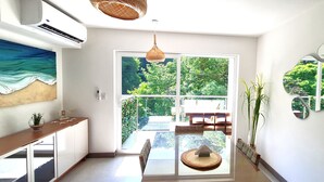 Eine moderne Küche mit großem Fenster, einem Esstisch und einer Pendelleuchte.