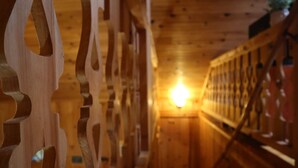 A wooden interior with a staircase and a light source at the end of the corridor. - Deer Meadow-Devil`s Bathtub/Natural Tunnel (Duffield)