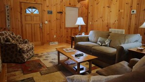 A cozy wooden-furnished living room with a sofa, armchair, and coffee table. - Deer Meadow-Devil`s Bathtub/Natural Tunnel (Duffield)