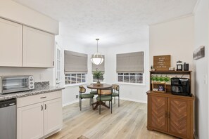 A kitchen with a dining table, chairs, a coffee maker, and a sign that says "STOP AND SMELL THE COFFEE". - Fayetteville Gem -Pet friendly / near Trilith Studios  (Fayetteville)