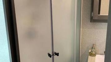 Ein Badezimmer mit Duschkabine, Waschbecken und Schrank.