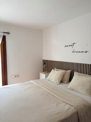 A bedroom with a bed, bedside table, lamp, and a wall with the text 'sweet dreams'. - Cala Dorada Residence in Cala D'Or (Santanyí)