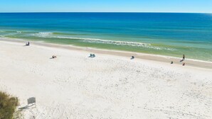 A wide sandy beach with clear blue water and a few people. - Private Pool, Carriage House, and Near the Beach (Destin)