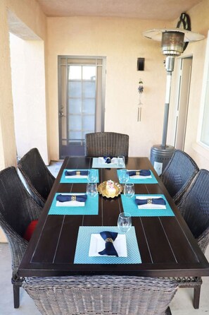 A dining table set with blue placemats, white napkins, and clear glasses.