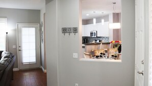 Une cuisine moderne avec des meubles blancs, un four à micro-ondes et un coin repas comprenant une table et des chaises.