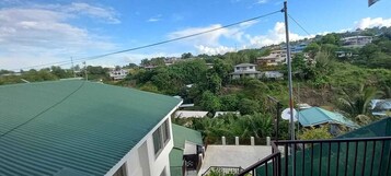Um bairro residencial com casas, um edifício com telhado verde e céu claro.