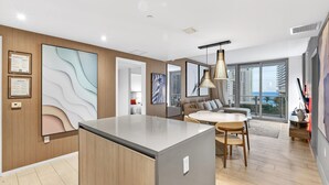 Una sala de estar moderna con una isla central, un sofá y un comedor.