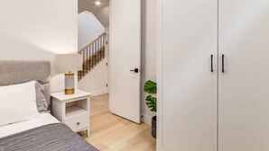 Un dormitorio con cama, mesita de noche y armario.