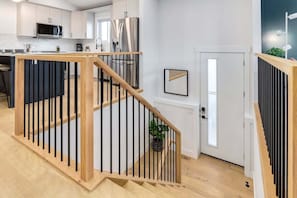 Una cocina moderna con armarios blancos, electrodomésticos de acero inoxidable y una isla de madera.