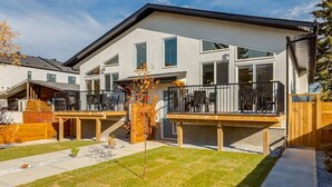 A modern two-story residential building with a deck and outdoor seating area. - Guest Favourite, King B, Family Friendly (Calgary)