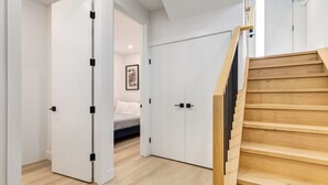 A room with a bed, a white wardrobe, and a wooden staircase. - Guest Favourite, King B, Family Friendly (Calgary)