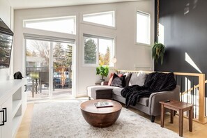 A modern living room with a sofa, coffee table, and a large window.