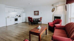 Una sala de estar moderna con una mesa de centro de madera, un sofá tapizado en rojo y un comedor con mesa y sillas.
