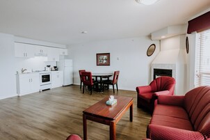 Una sala de estar moderna con una mesa de centro de madera, un sofá tapizado en rojo y un comedor con mesa y sillas.