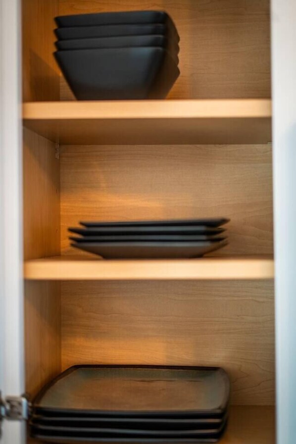 A wooden shelf with black storage boxes.
