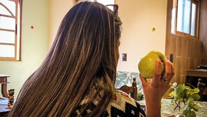 A person sitting indoors, holding a green apple. - SiempreViva Hospedaje By GEstores (Chignahuapan)