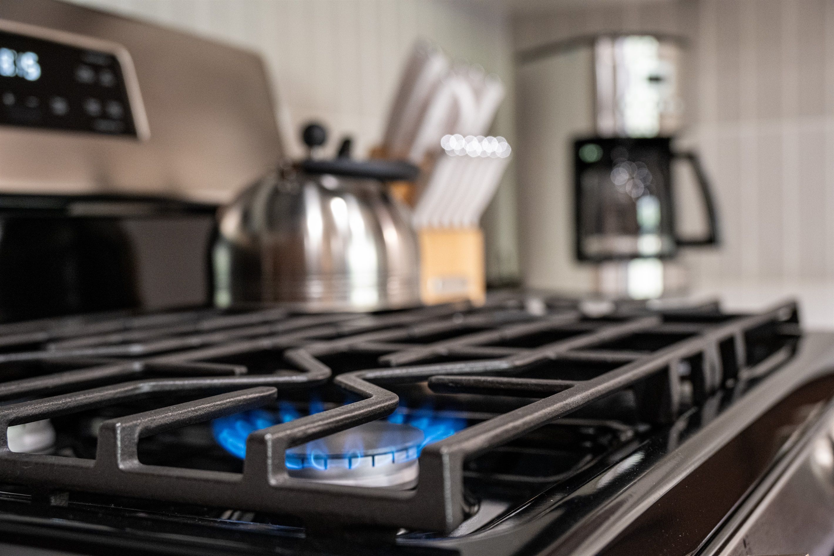 A coffee maker, kettle, and gas stove for the morning breakfast cuisine.