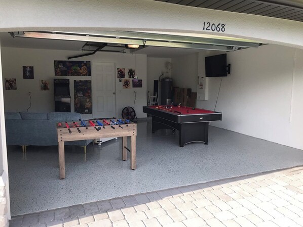 Une pièce équipée d’un baby-foot, d’une table de billard et d’un canapé.