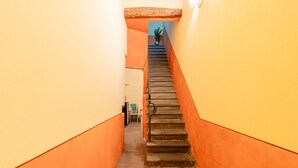 A narrow staircase with orange walls and a carpeted floor leading to a door at the top. - San Giorgio A Apartment - Lucca with Wi-Fi (Lucca)