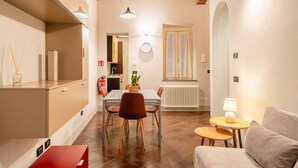 A modern kitchen with a dining area, wooden ceiling beams, and a visible kitchen counter. - San Giorgio A Apartment - Lucca with Wi-Fi (Lucca)