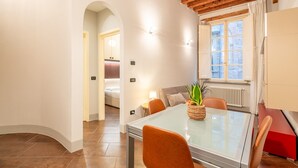 A modern hotel room with a glass dining table, wooden ceiling, and a view of the outside. - San Giorgio A Apartment - Lucca with Wi-Fi (Lucca)
