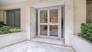 A building entrance with a sign reading 'Palais Henri IV,' a glass door, and a number '18' on the wall. - Superb apartment in Nice: comfort and charm in the heart of the city (Nice)