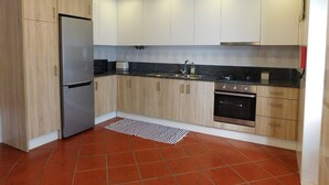 A modern kitchen with a refrigerator, oven, and microwave. - Holiday Home 'Casa Da Veiga - Natureza E Cidade' with Private Terrace, Wi-Fi and Air Conditioning (Lago)