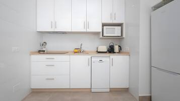 Een koelkast, een magnetron, een kookplaat, een vaatwasser