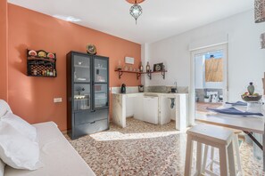A compact living space with a kitchenette, a bed, and a dining area.