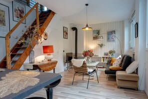 A modern living room with a staircase, a dining table, and a sofa. - Holiday Home “La Villa” with Mountain View, Private Terrace and Wi-Fi (Viviers-du-Lac)